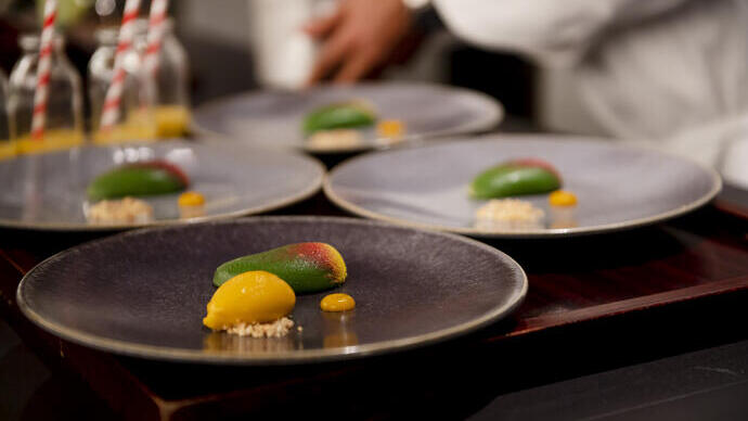 Four dishes of food on a table being prepared in a restaurant