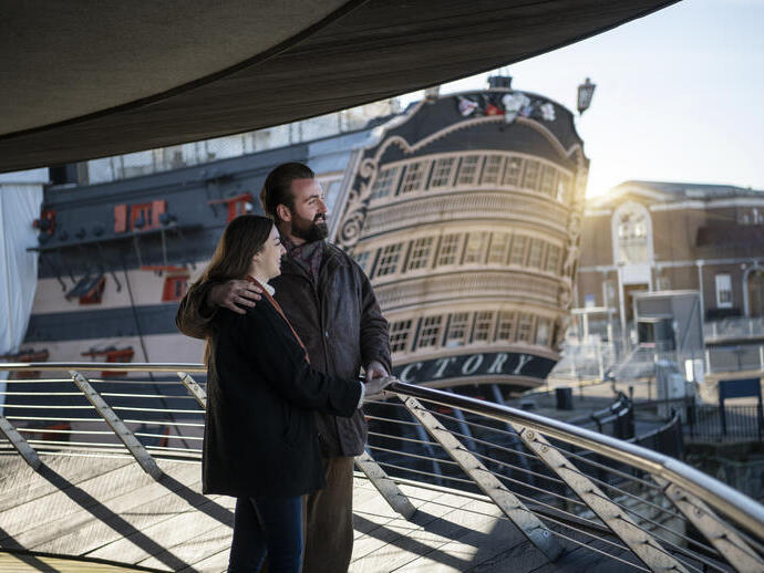 Two people looking over the bow of a ship