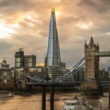 Modern and traditional buildings and bridge looking across a river with a boat in the foreground