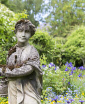 Lichen and moss covered statue at Crook Hall Gardens, County Durham