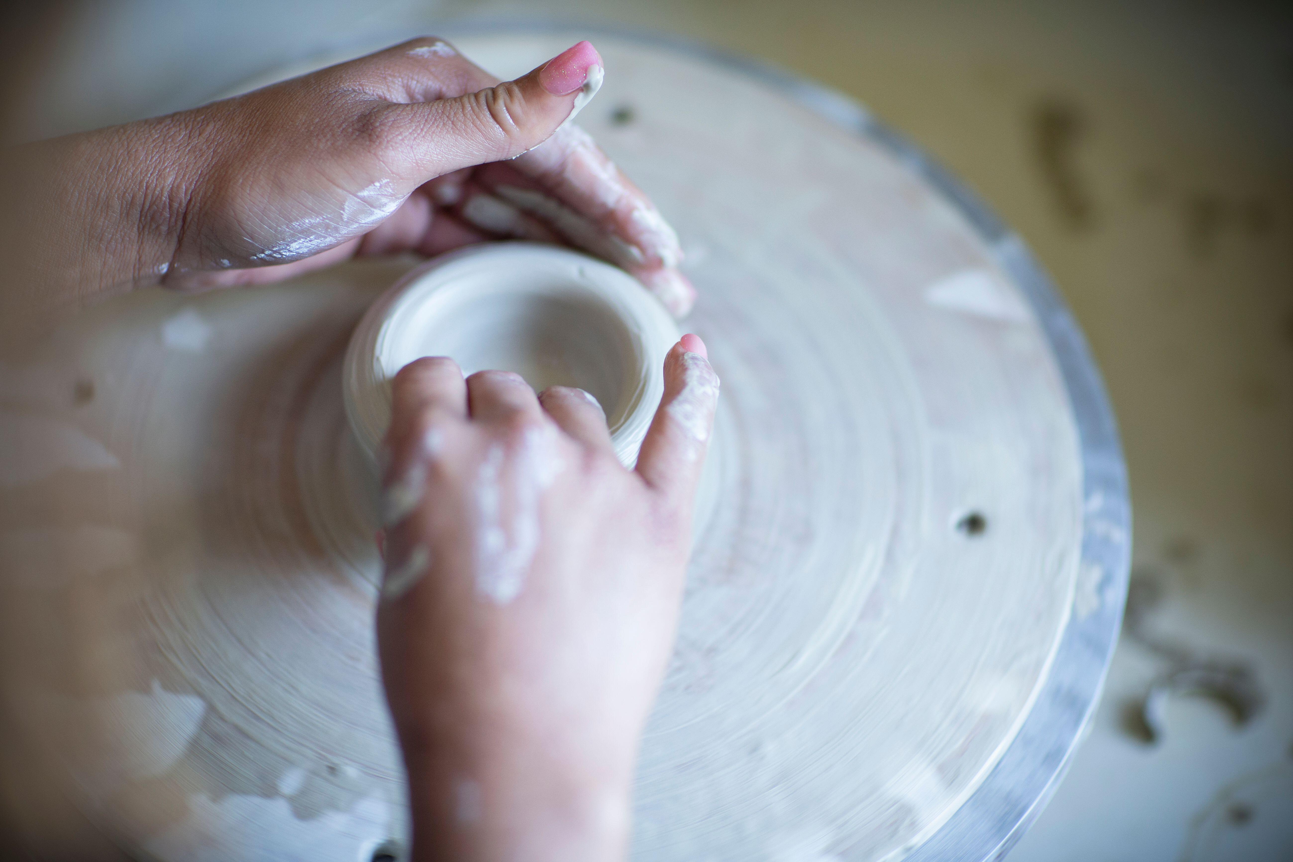 Close up female artist at pottery wheel