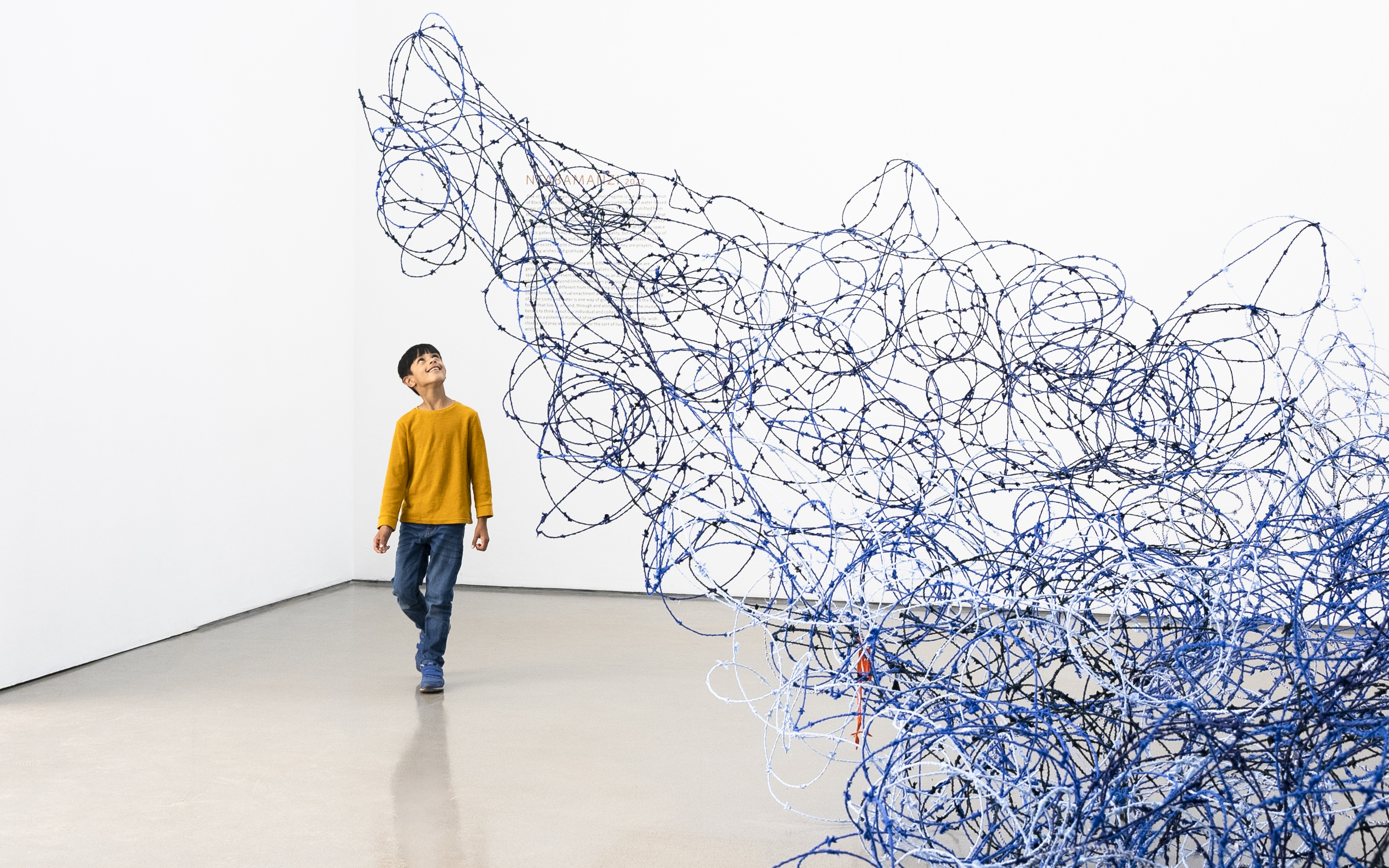 Un enfant regardant une exposition d'art à la galerie d'art de Leeds