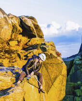 A rock climber considering a descent