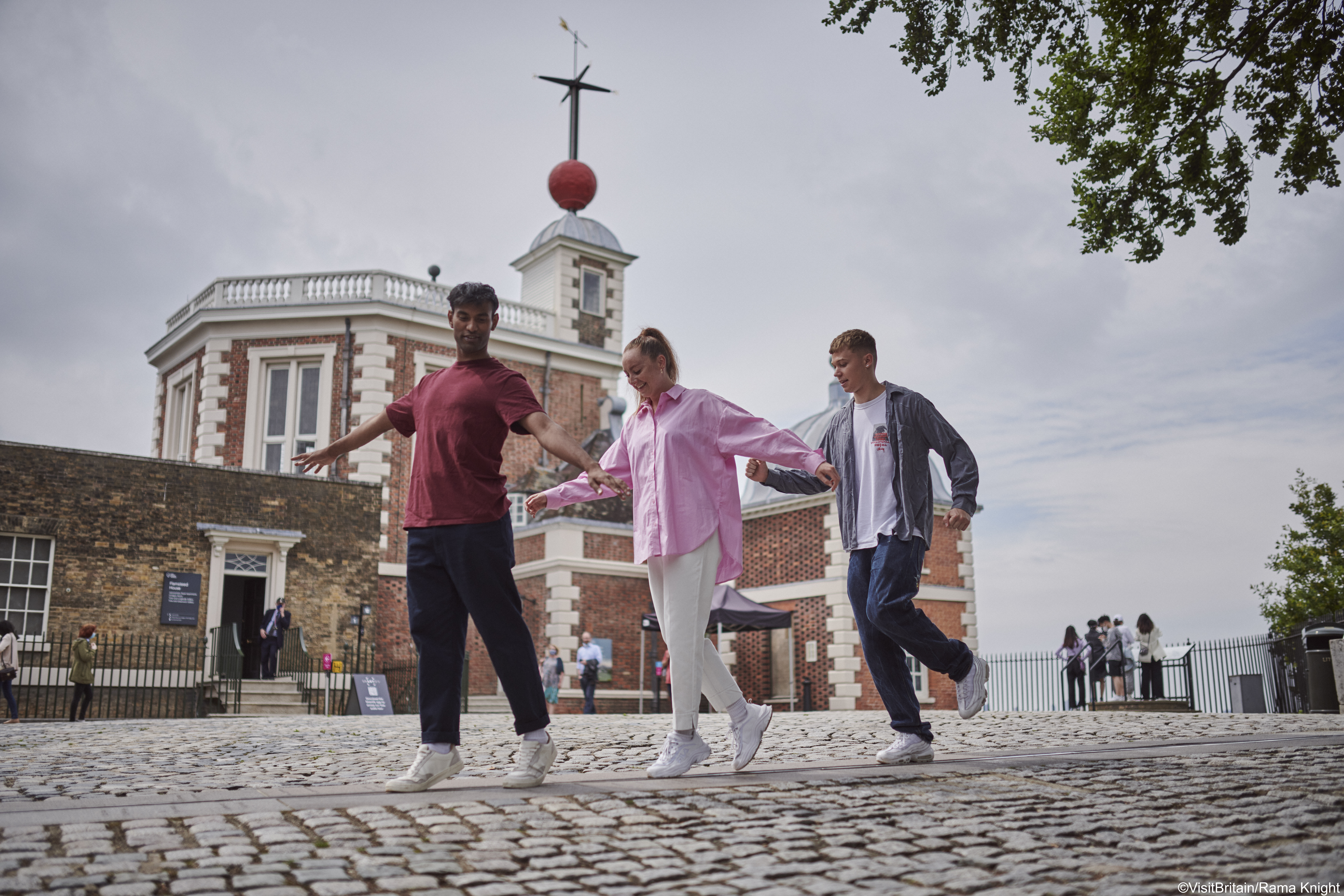 A group of people walking the Prime Meridian line at Greenwich Observatory, London