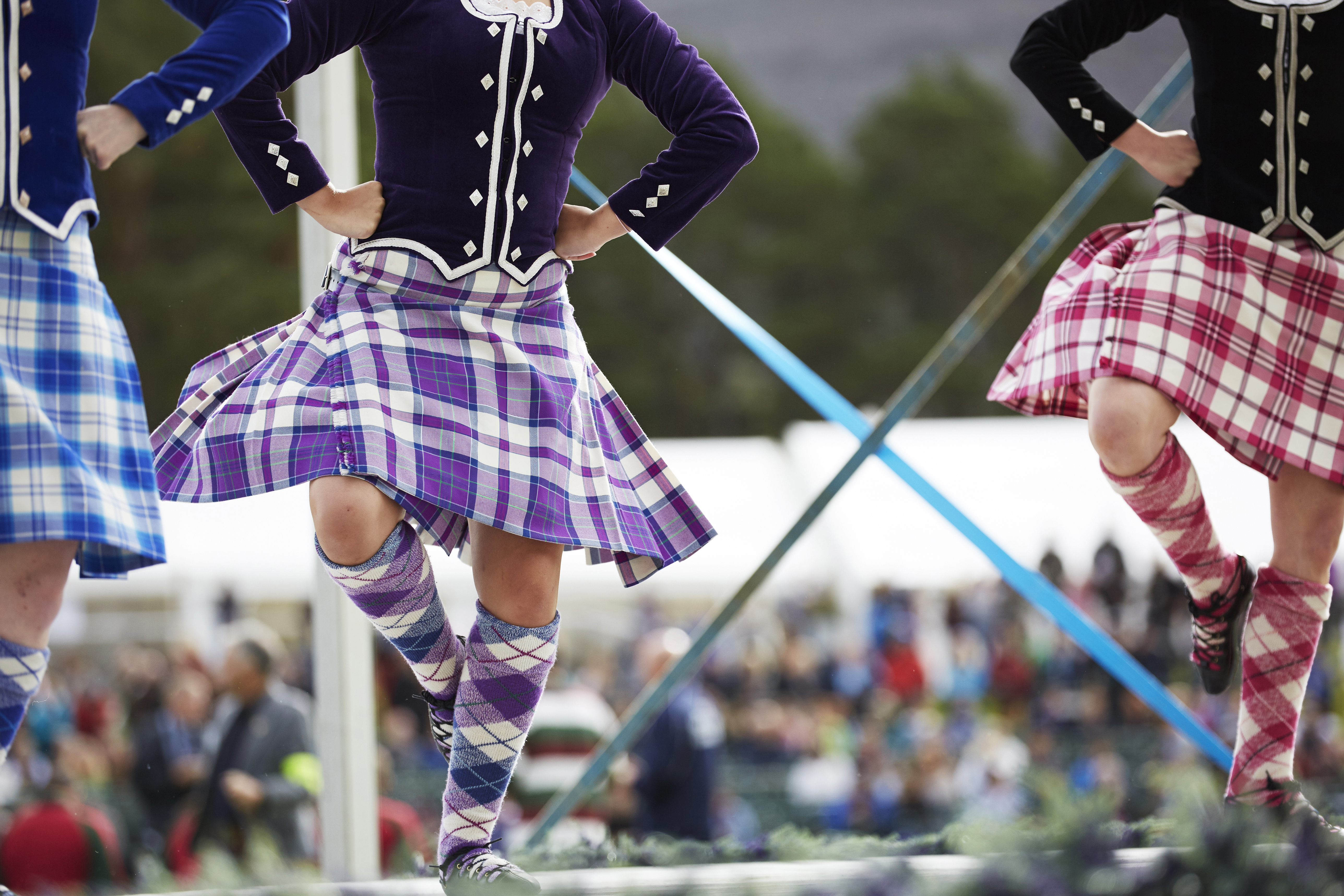 Tre ragazze in kilt che ballano danze scozzesi sul palco
