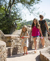 A family walk over Lovers' Bridge at Dunster Castle, Somerset