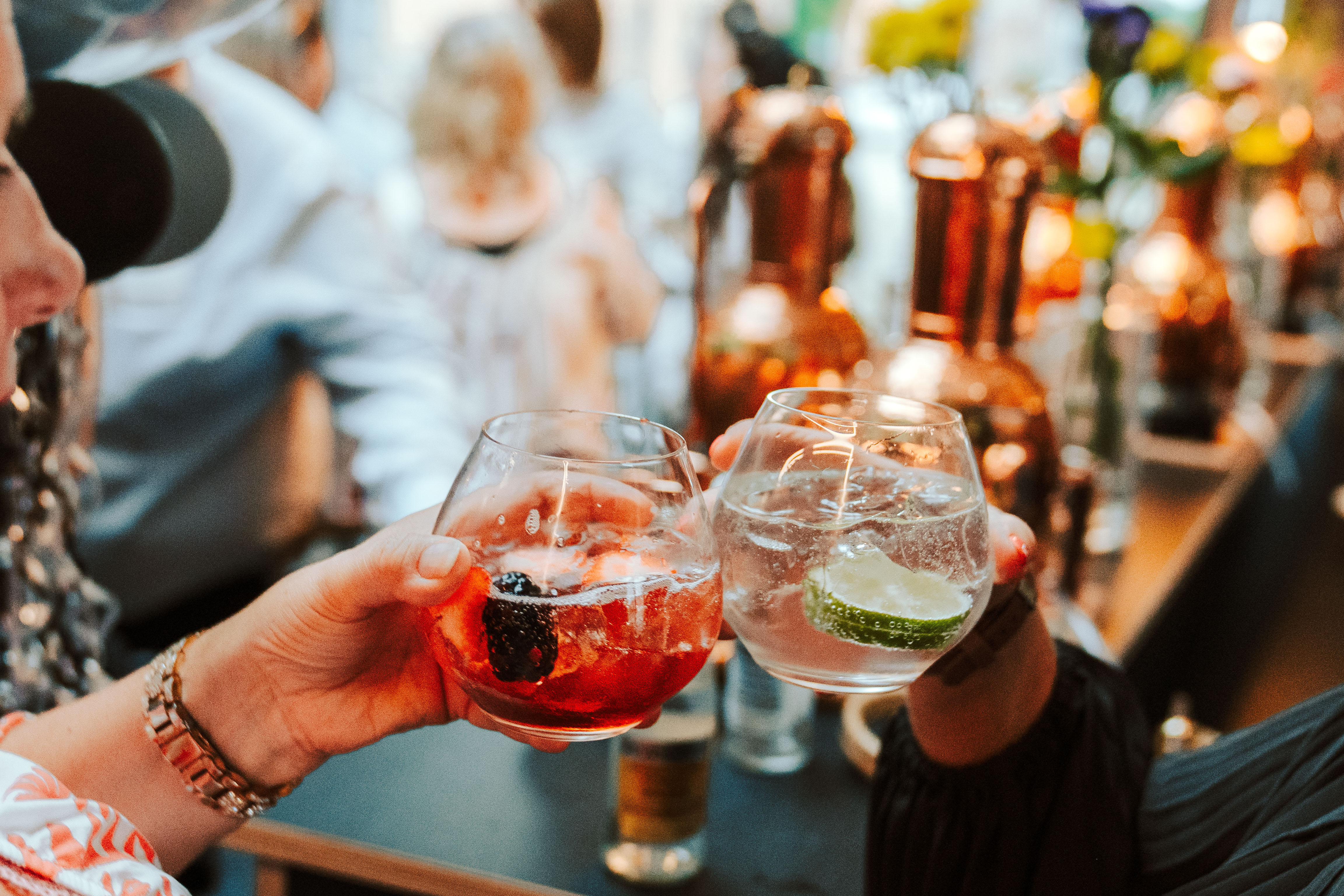 Two people toast cocktail drinks