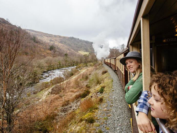 Frau und Kind, die sich aus dem Fenster eines Dampfzuges lehnen
