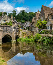 Blue skies and reflections in the picturesque Cotswold village of Castle Combe.