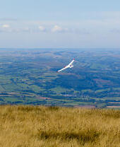 A glider cruising across local rural fields.