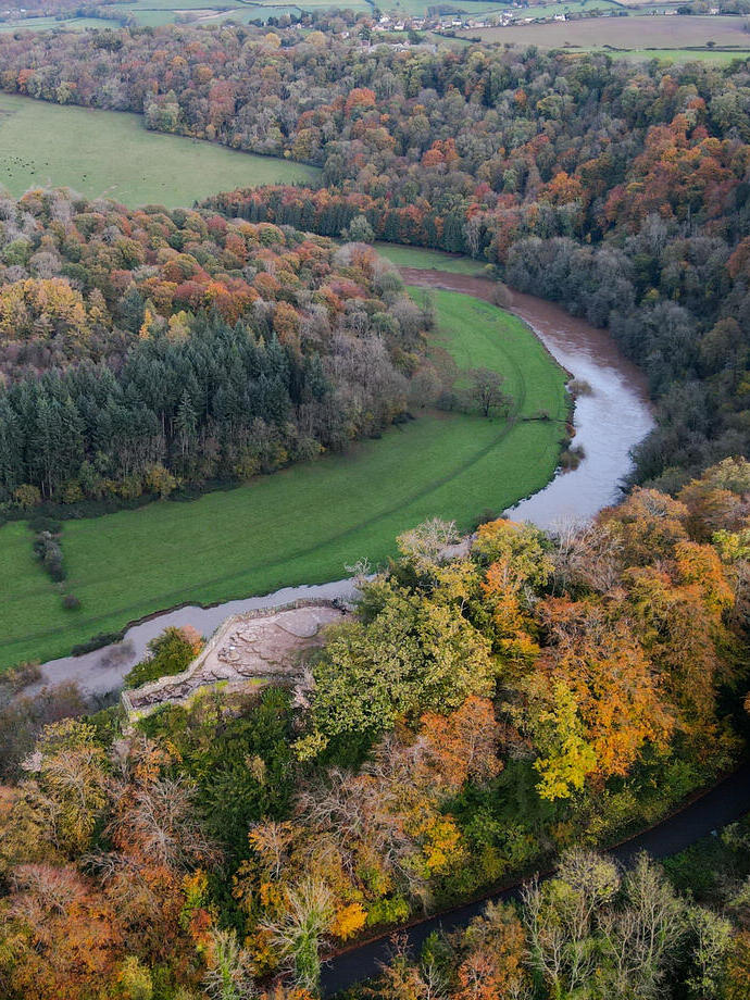 A rocky outlook on a hill in a forest with a river down below.