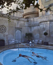 Pareja en una piscina termal al aire libre en un balneario