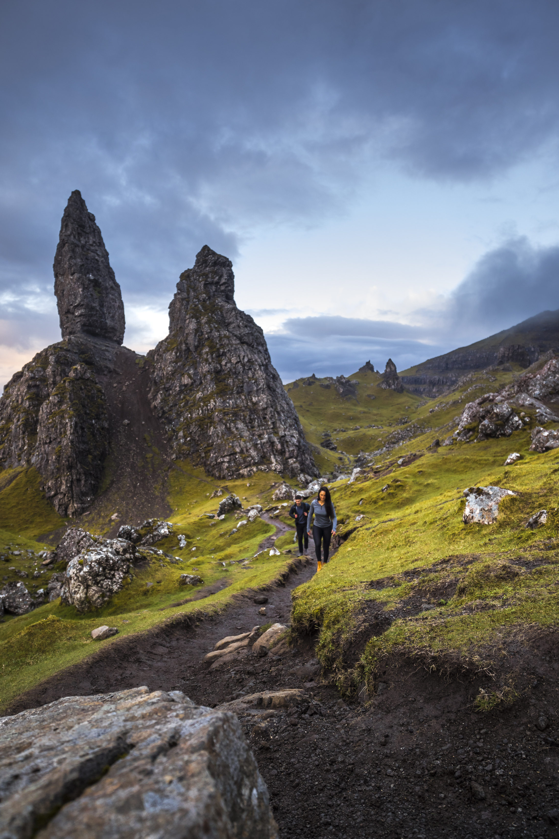 Couple hiking near basalt pinnacles. Cloudy skies