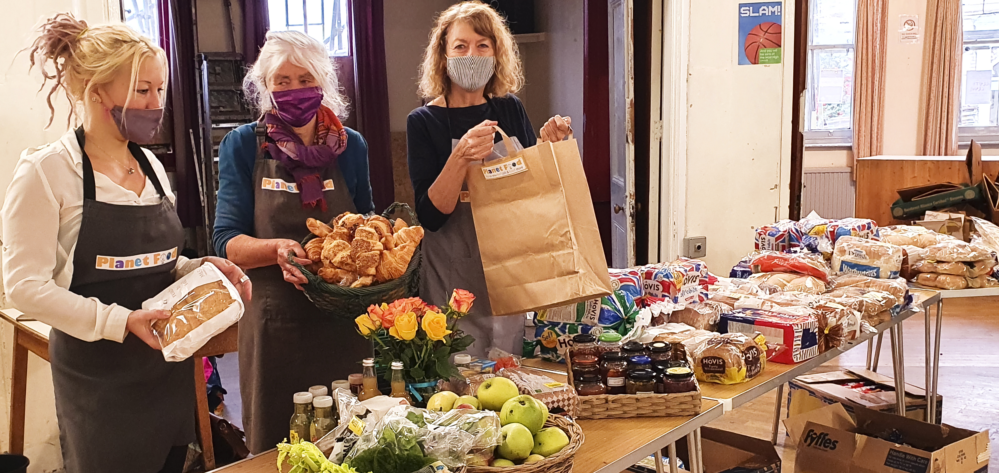 Women serving food at a table in Planet Food, a community cafe and store in York