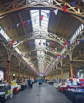 Vue intérieure d'étals en cours d'installation dans un marché couvert.