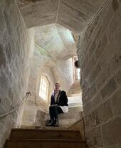 Découvrez l'histoire de manière interactive, femme assise sur un escalier en colimaçon à l'intérieur d'un bâtiment