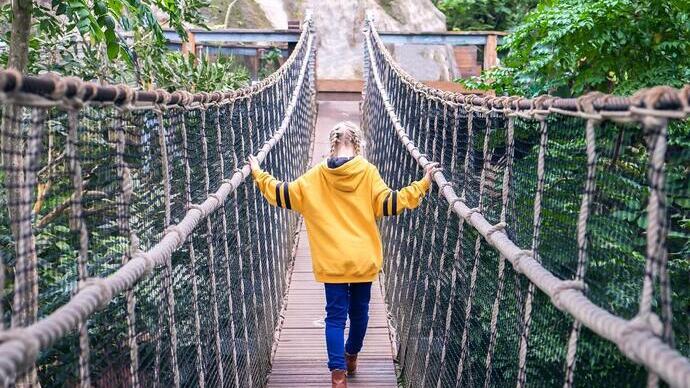 Fille traversant un pont à l'Eden Project