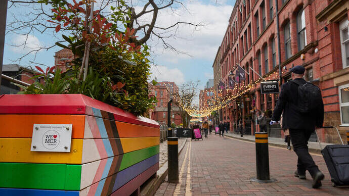 Pedestrians walking along a canal side shopping precinct.