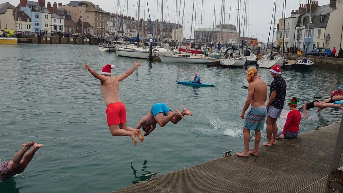 Nuotata gelida a Weymouth con barche sullo sfondo