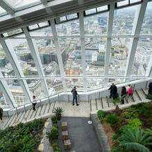 People walking down the stairs Sky Garden wth the city in the background