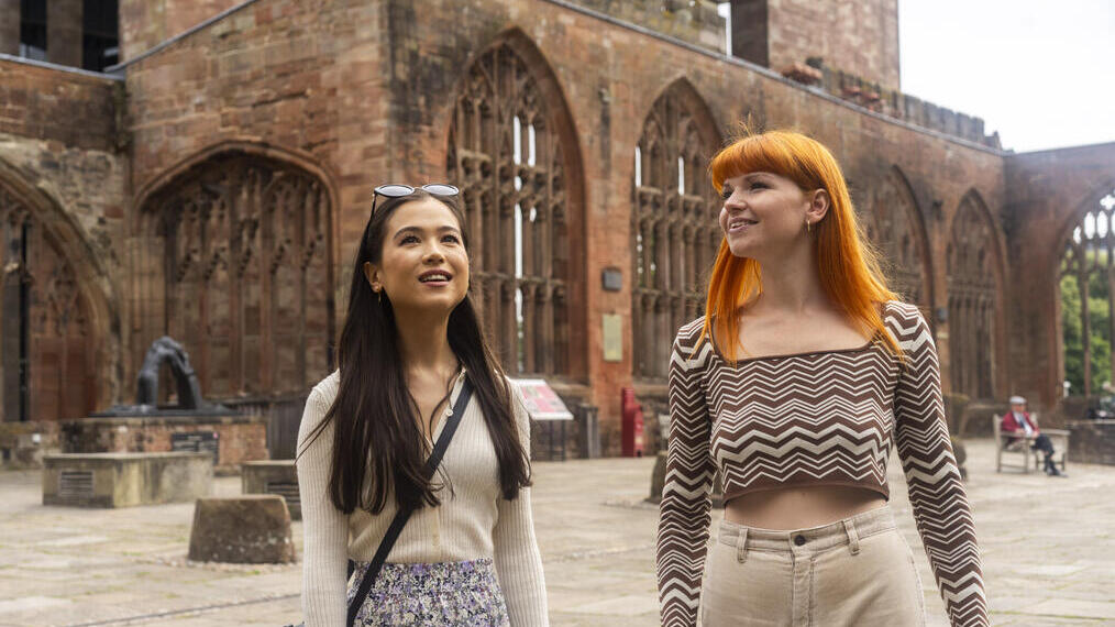 Two women explore the ruins within the grounds of a Cathedral