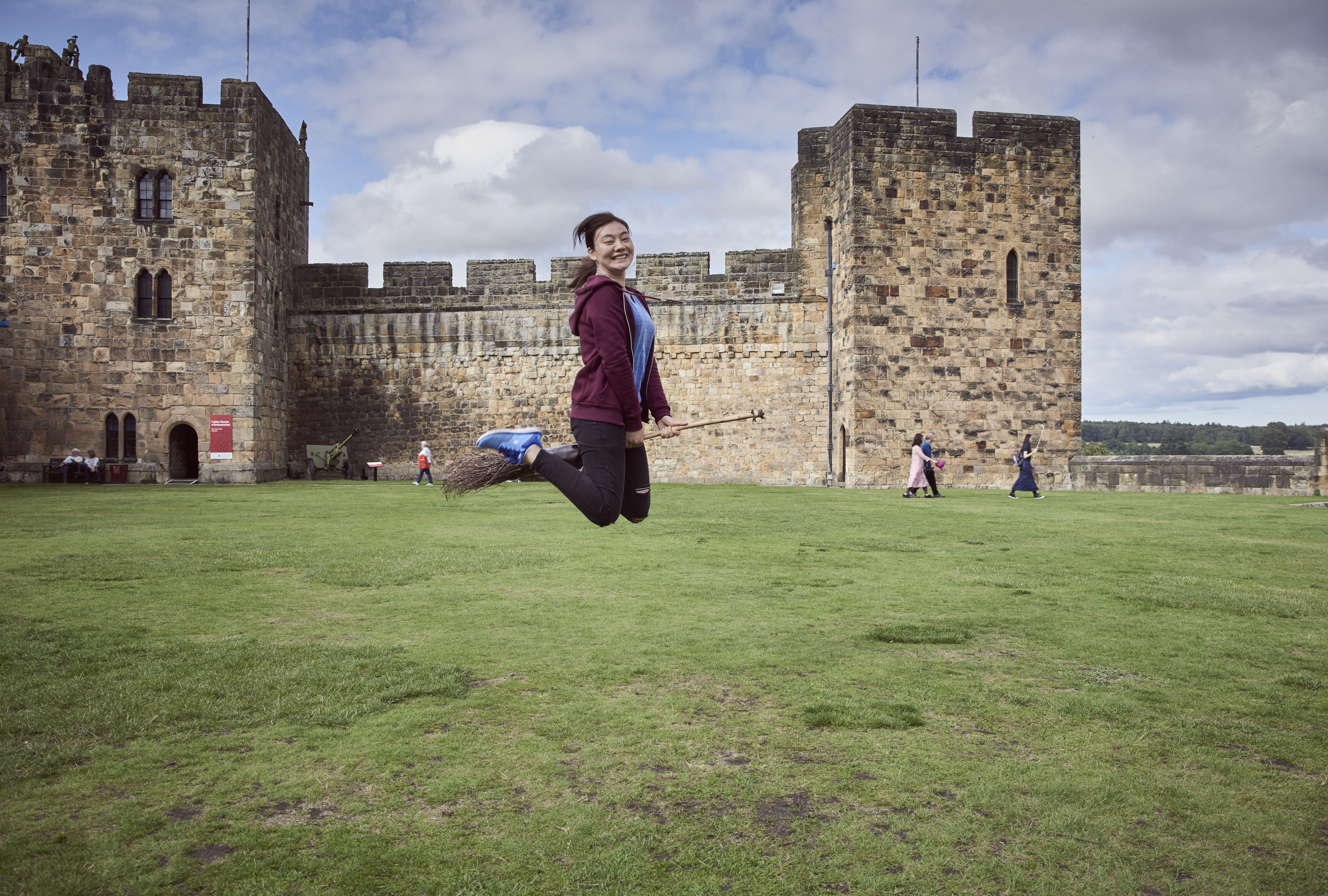 Woman on a broomstick outside a castle