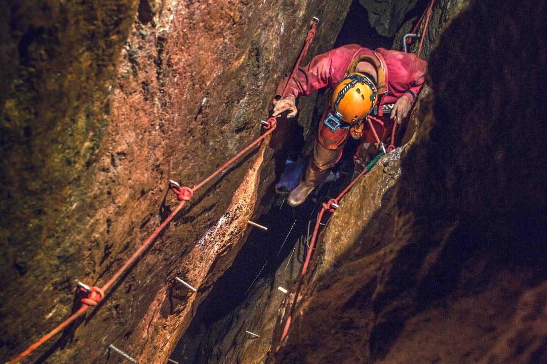 A man exploring through a cave system at Cornwall Underground Adventures