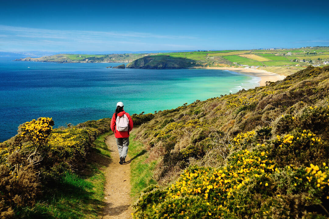 A person on a footpath on the coastal path near sea