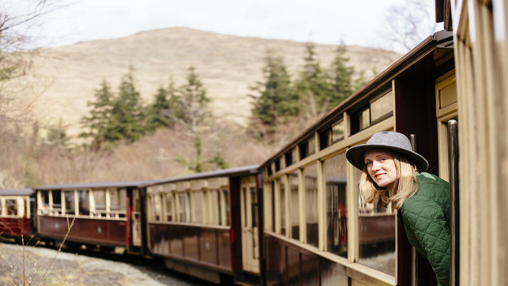Woman leaning out of window of steam train