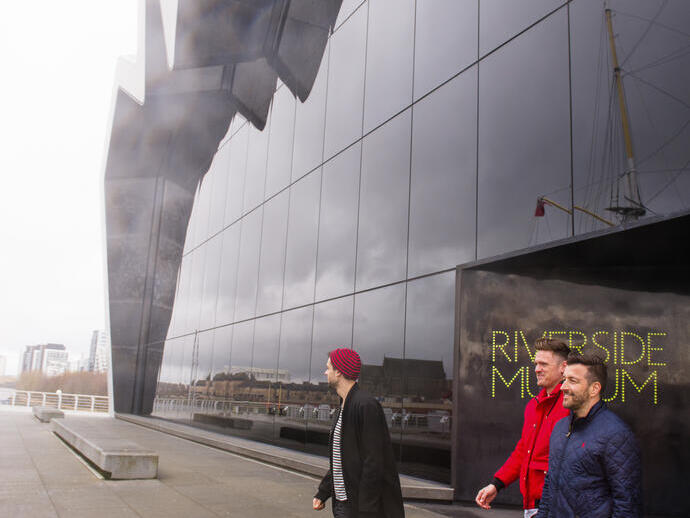 Three men exiting the Riverside Museum