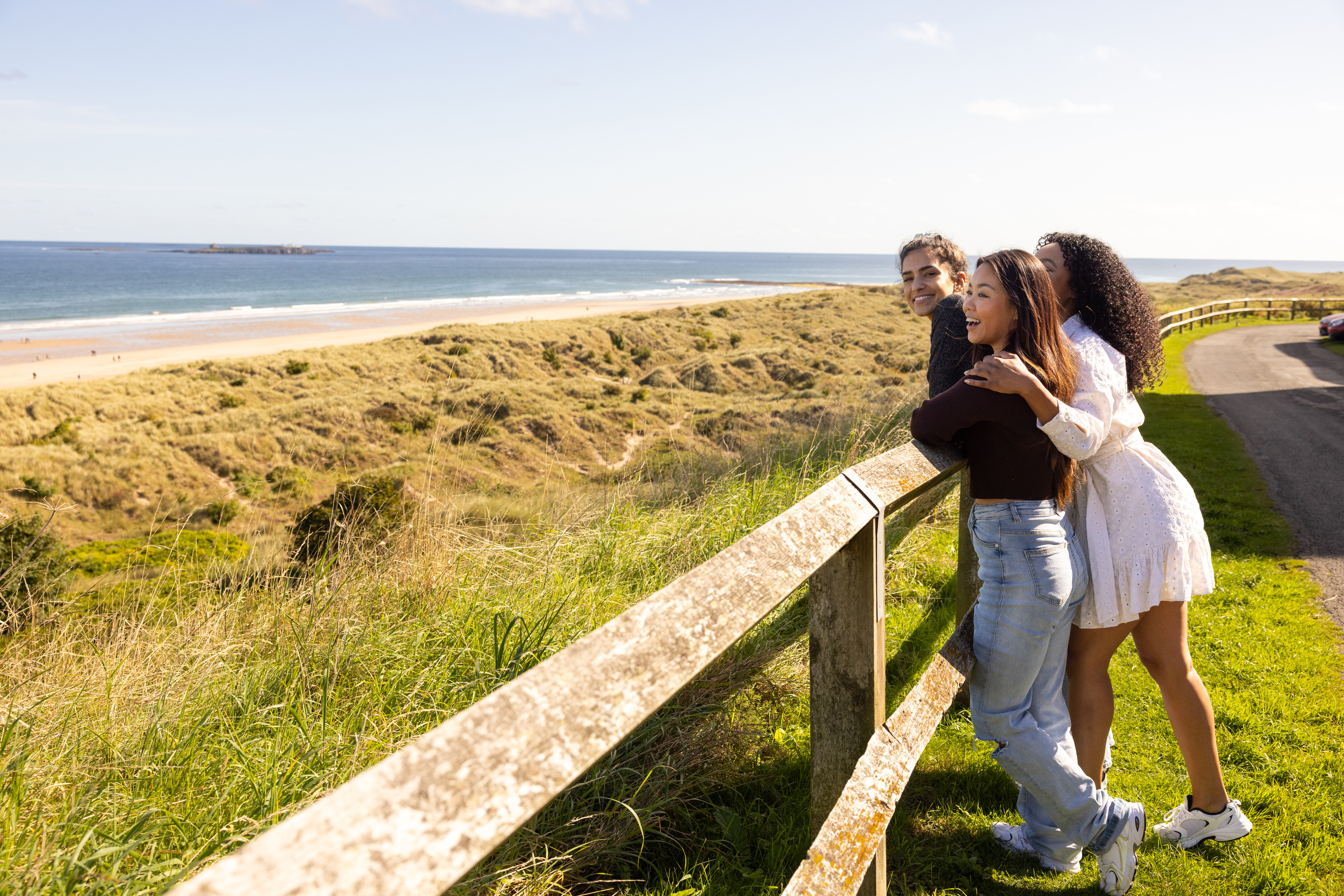 Friends looking out at the beach at Bamburgh Castle