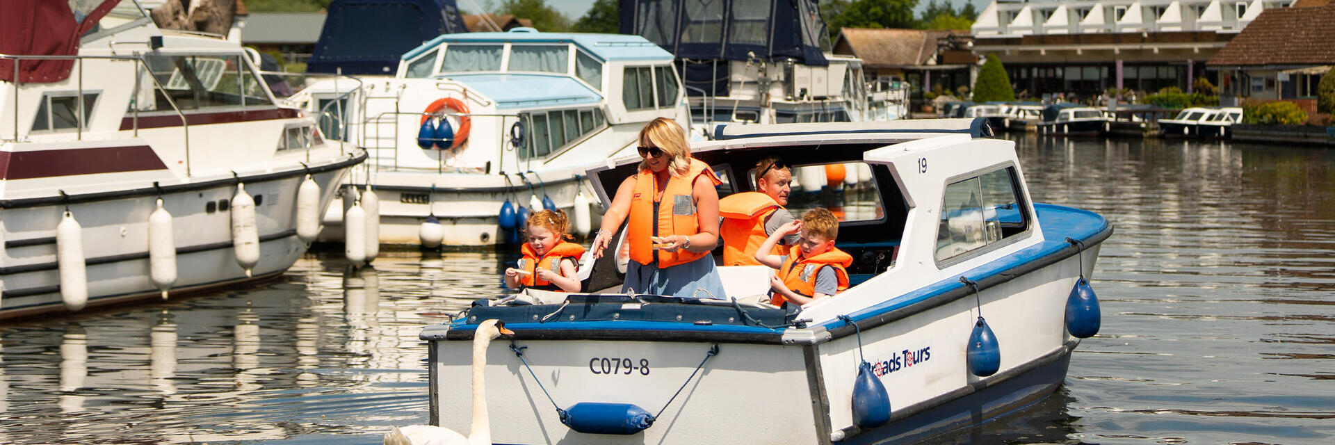 Una famiglia su una barca nelle Norfolk Broads