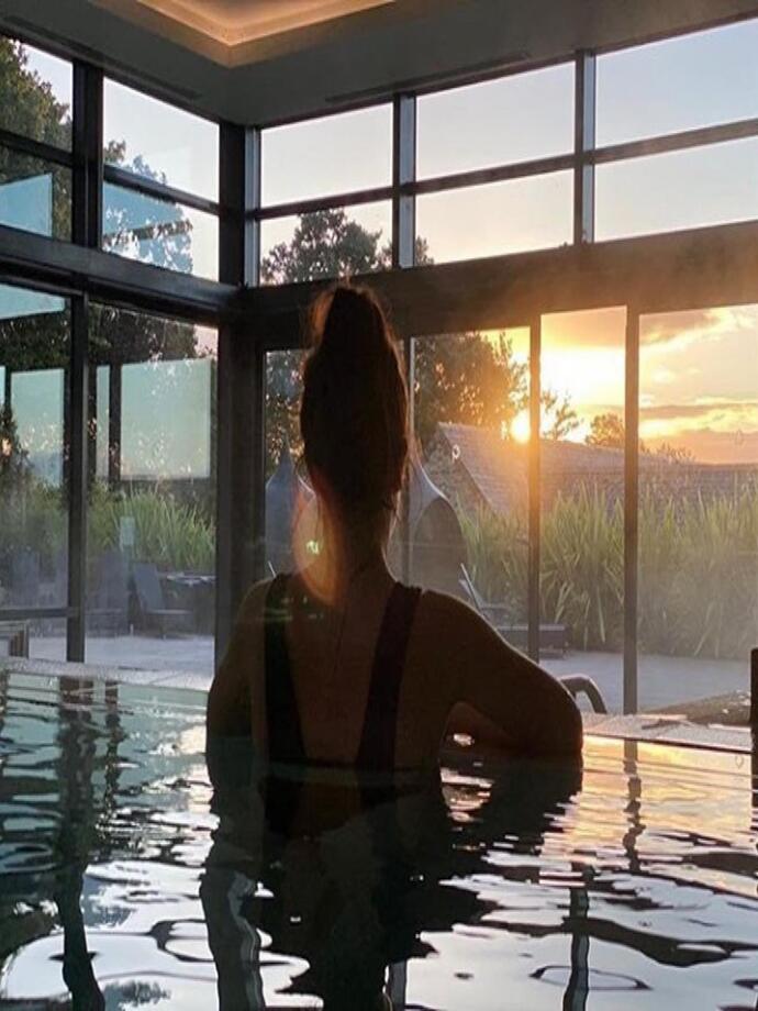 woman in pool at Gaia Spa looking out of the window at sunset