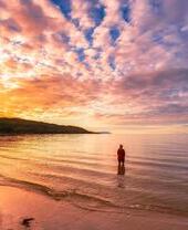 Woman standing in water at Singing Sands beach