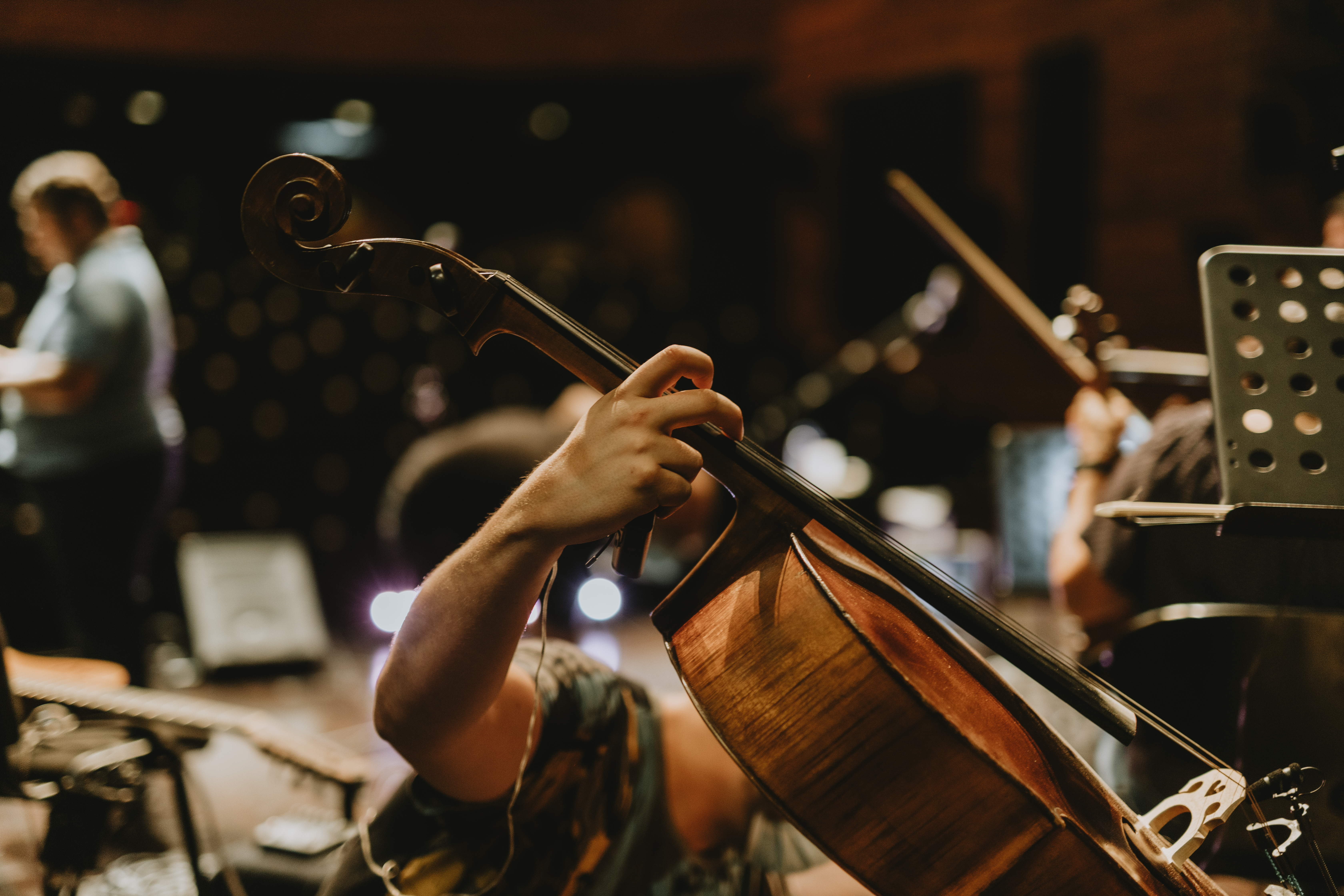 A man preparing a cello for a concert stage.
