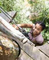 A child climbing up a tree at Go Ape Wendover