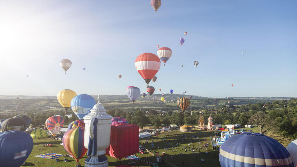 Globos aerostáticos de colores flotando sobre el campo
