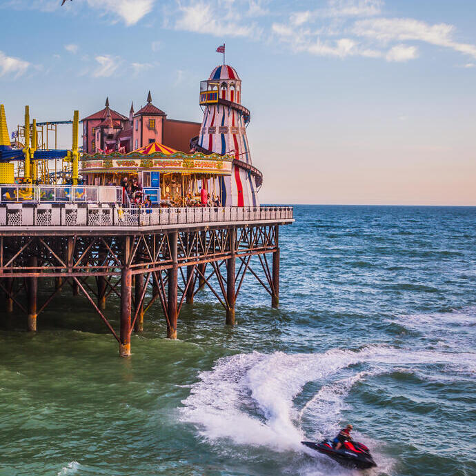 Un luna park alla fine di un molo con una moto d'acqua in mare