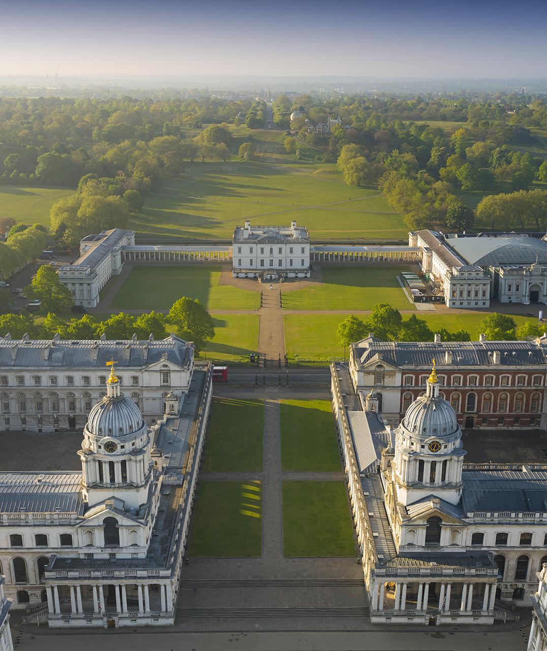 Aerial view of a massive mansion and manicured gardens.
