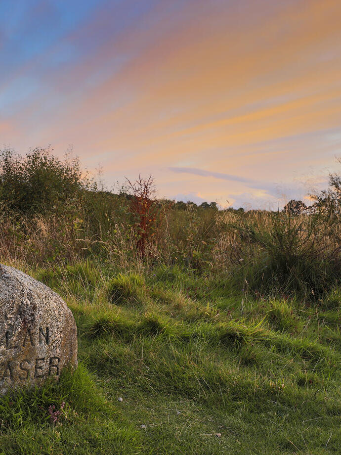Champ ouvert avec une pierre tombale portant l'inscription : Clan Fraser