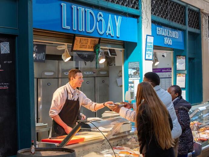 A fishmonger serving a customer at Grainger Market in Newcastle