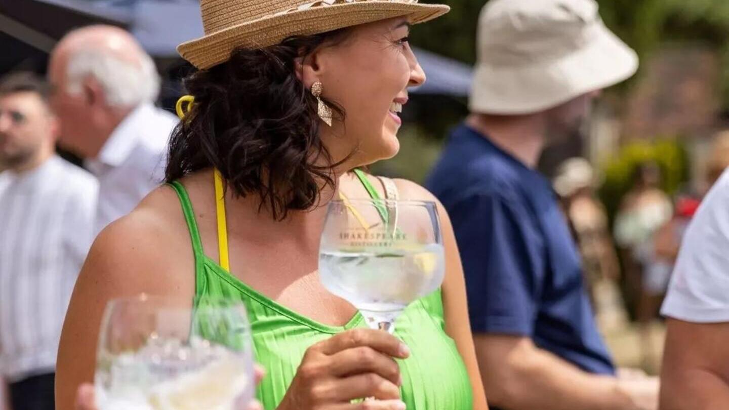 Une femme dégustant un gin à l'extérieur