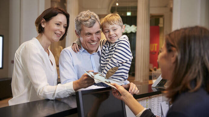 Family buying entry tickets in a museum