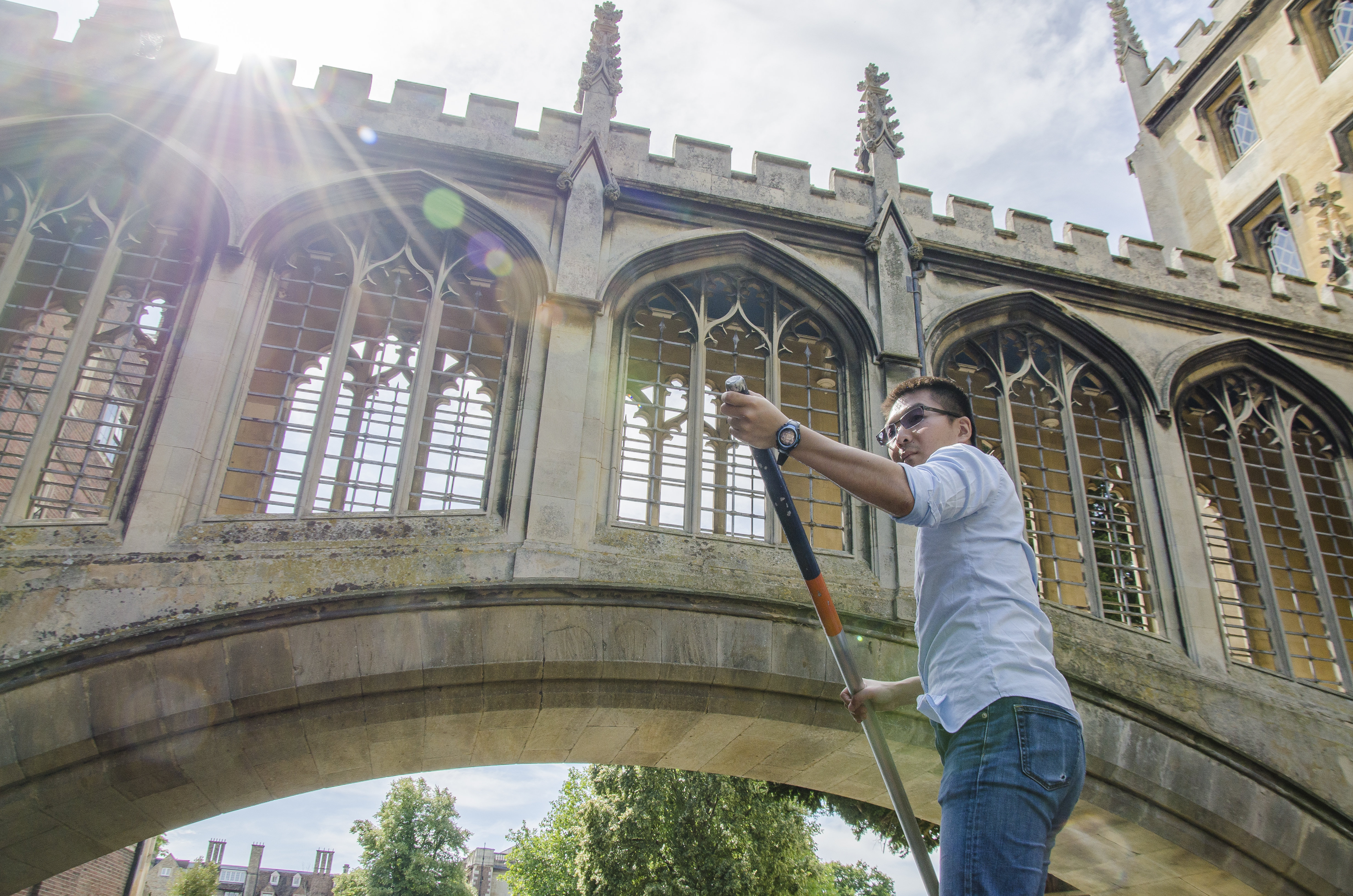 Low angle view of adult man punting beneath a bridge