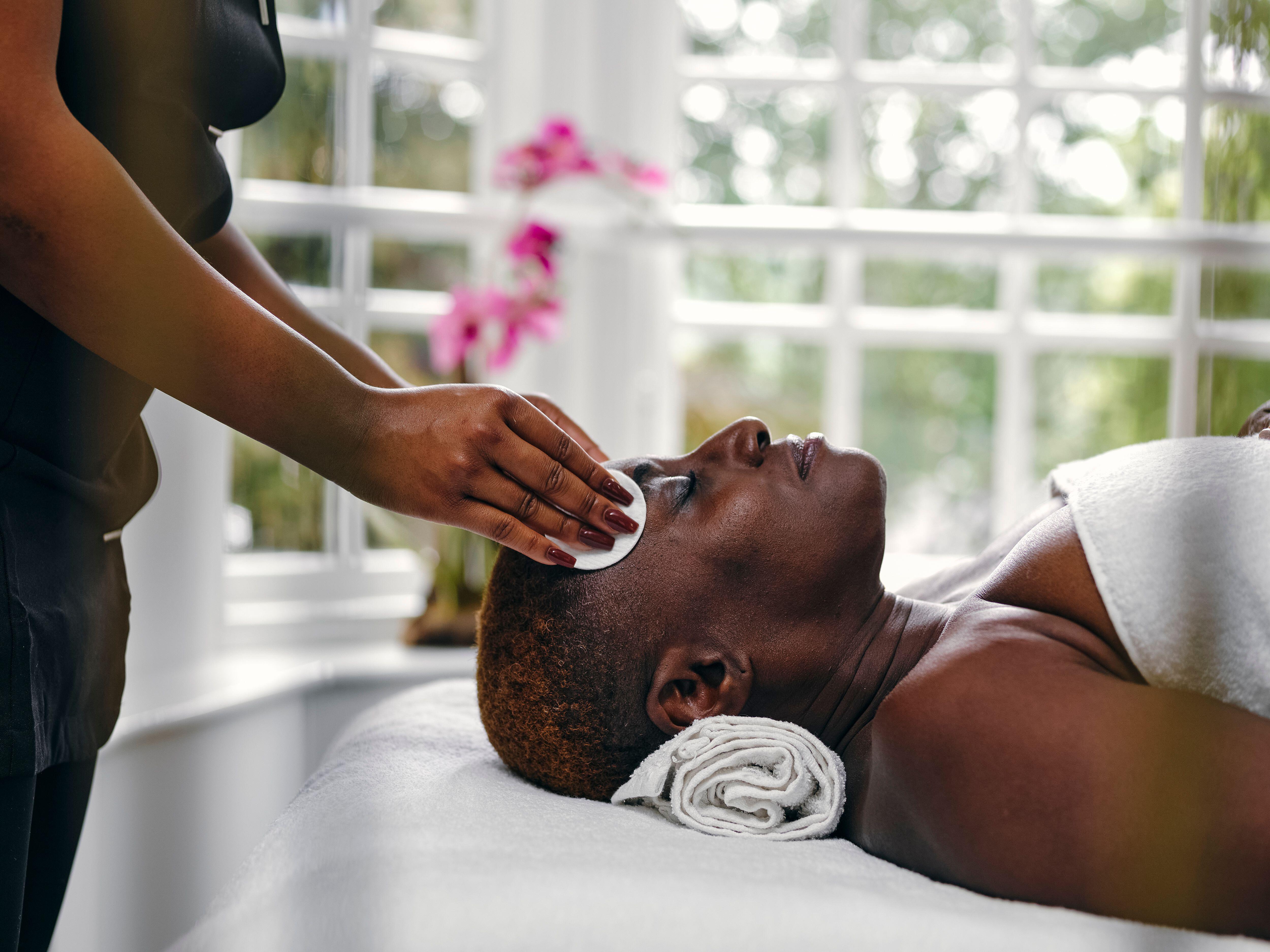 A woman getting a face massage at a hotel spa.