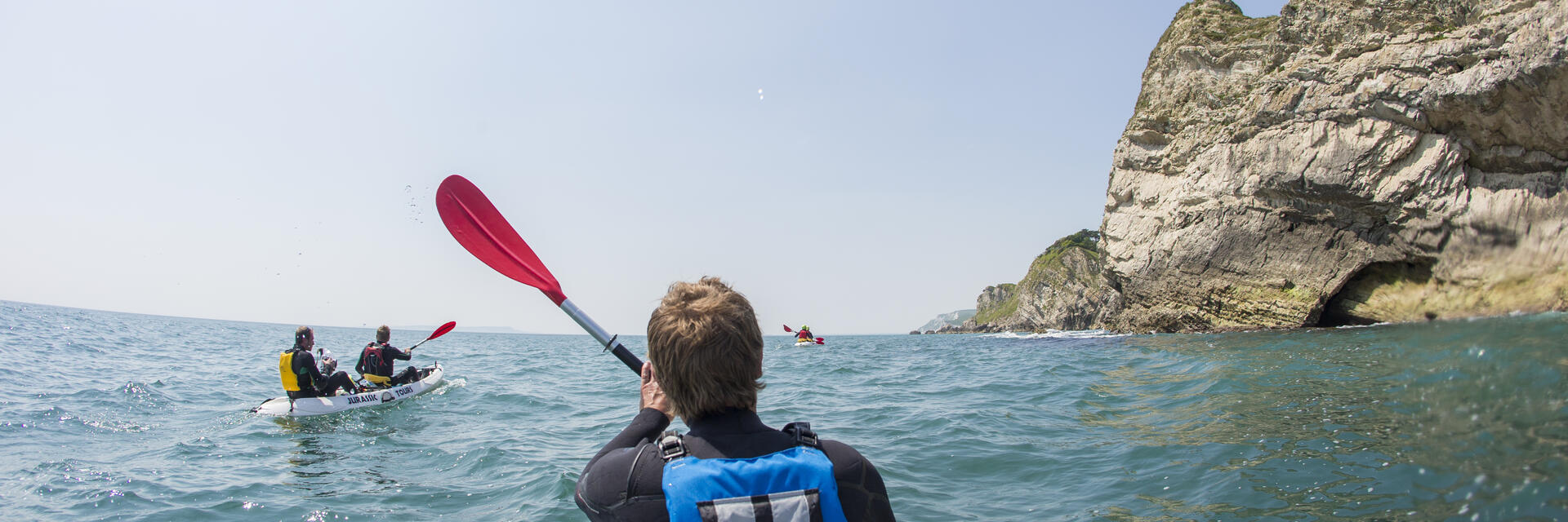 People kayaking along the shores of coastline