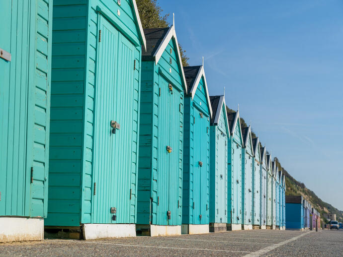 Colourful beach huts in a line.