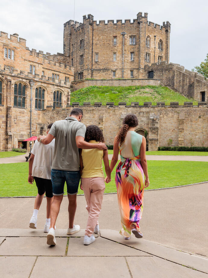A family exploring the grounds of a castle.