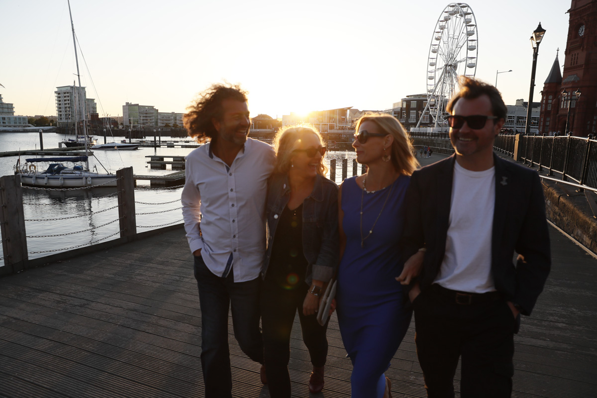 Eine Gruppe von Menschen erkundet den Hafen von Cardiff bei Sonnenuntergang