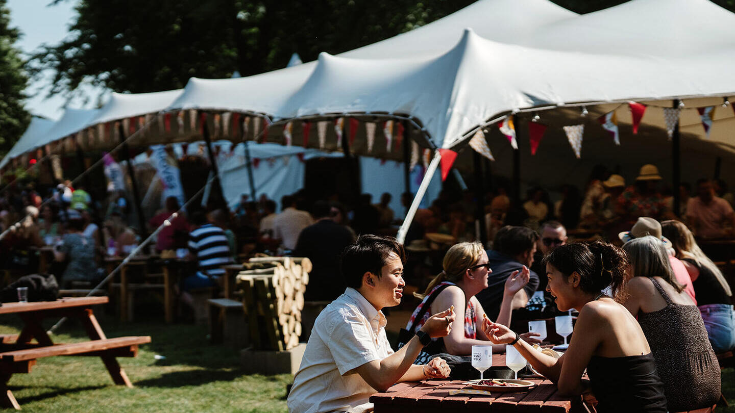 Groups of people sitting at tables and drinking wine at Norwich Wine Festival
